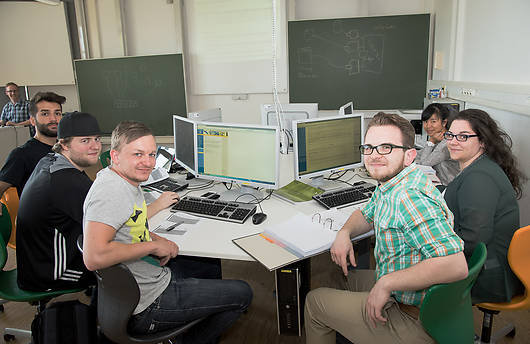 Mehrere Studenten bei der Teamarbeit im PC-Labor